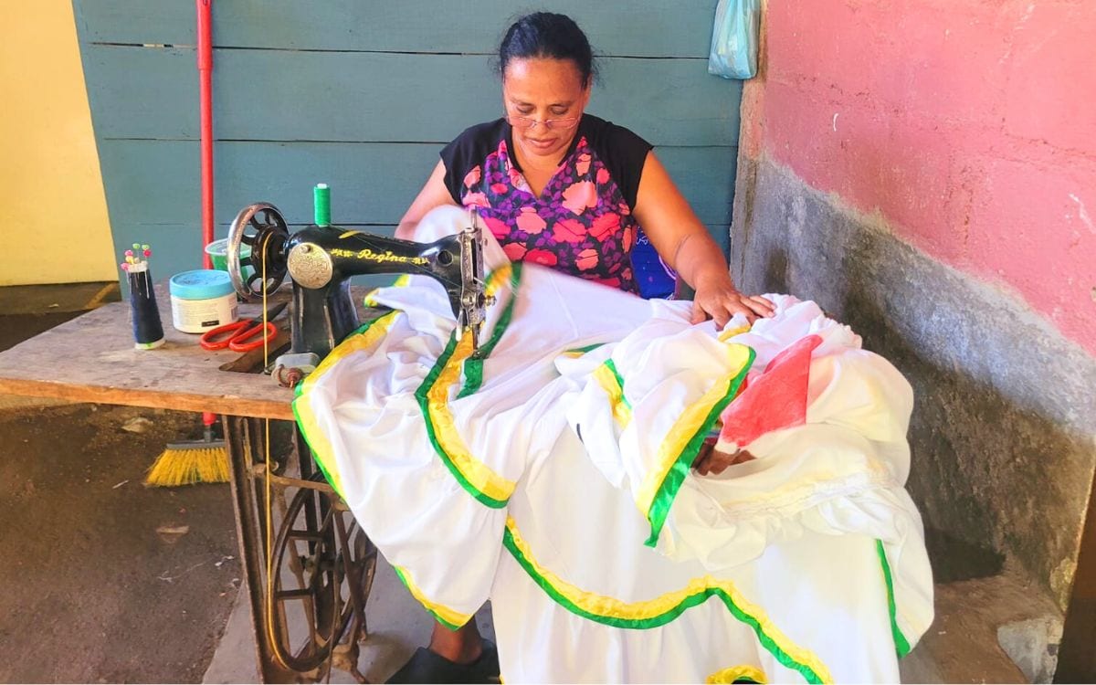 Lorena sewing a dress with an antique sewing machine