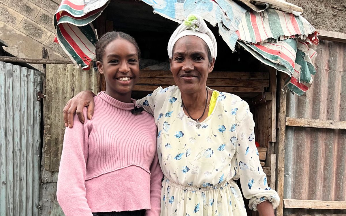 Marege and her mother outside their home in Ethiopia.