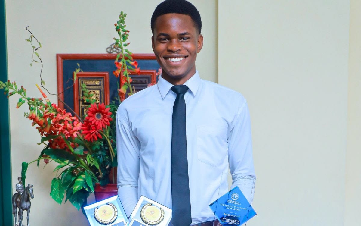 Kalou, Samaritan Scholar in Jamaica displaying some awards.